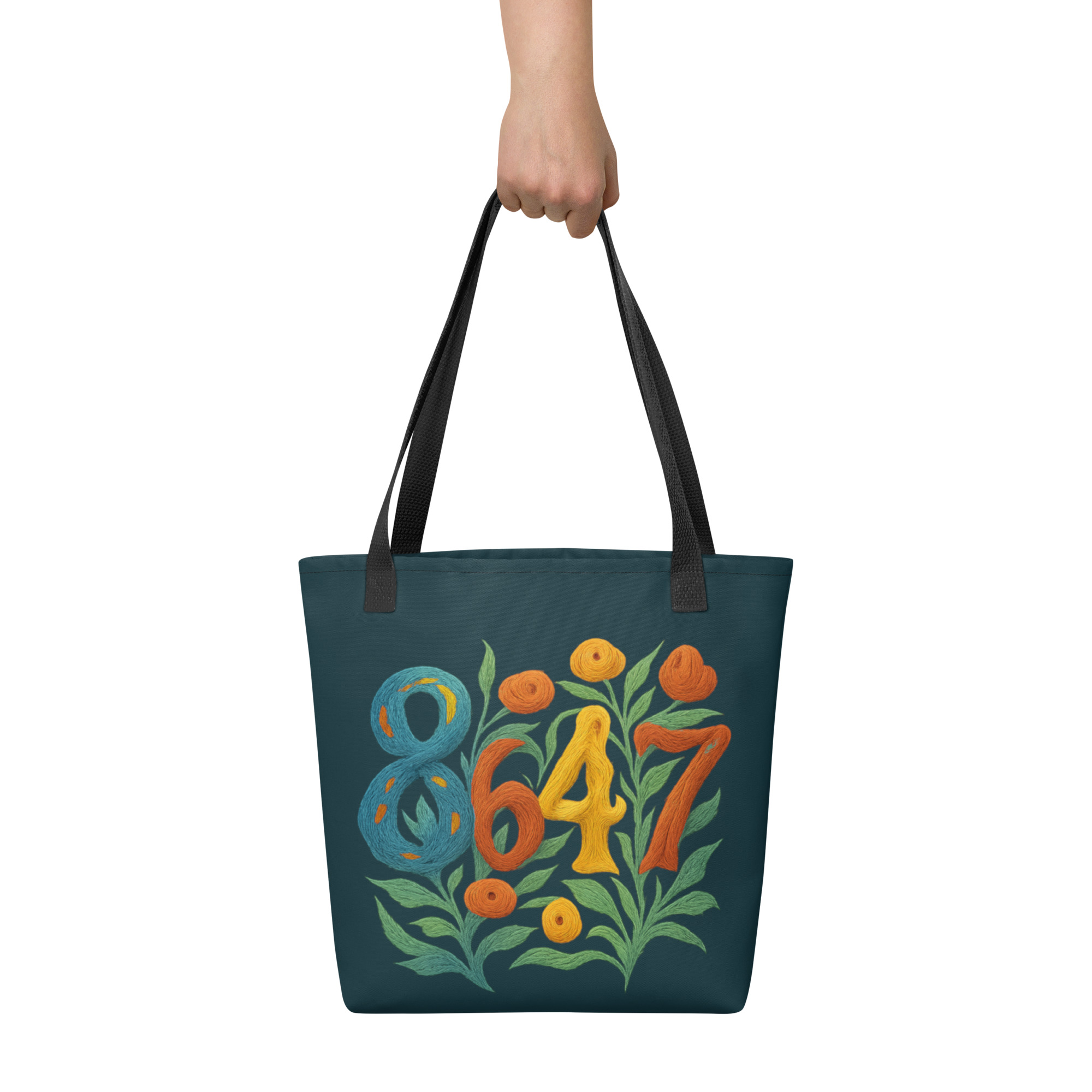 Hand holding a teal colored tote bag with black handles with 8647 graphic